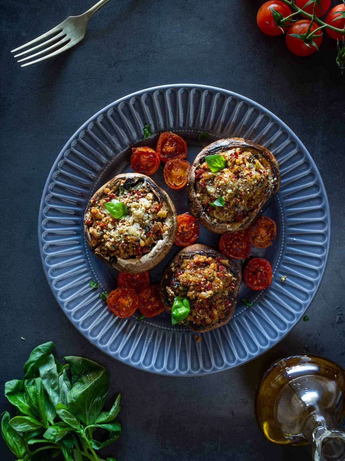 three stuffed portobello plated on a gray plate