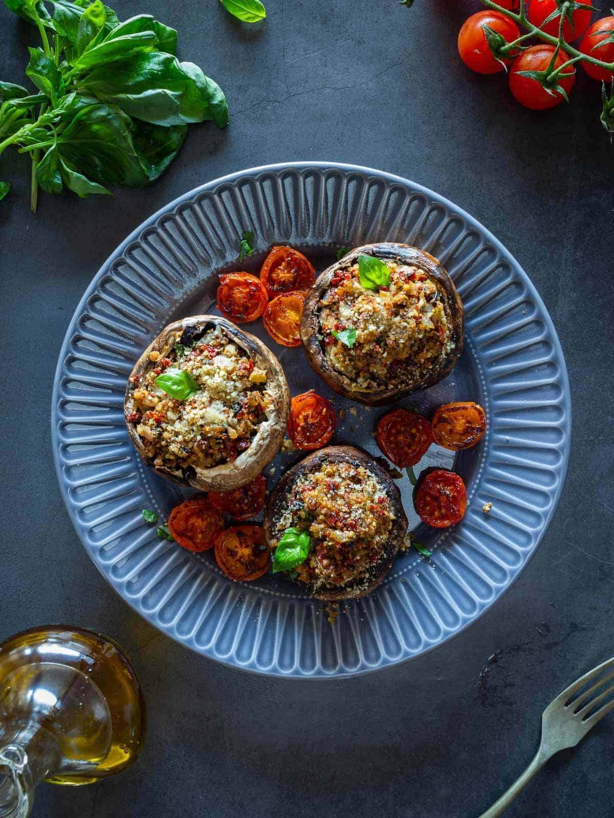 three stuffed portobello plated on a gray plate.