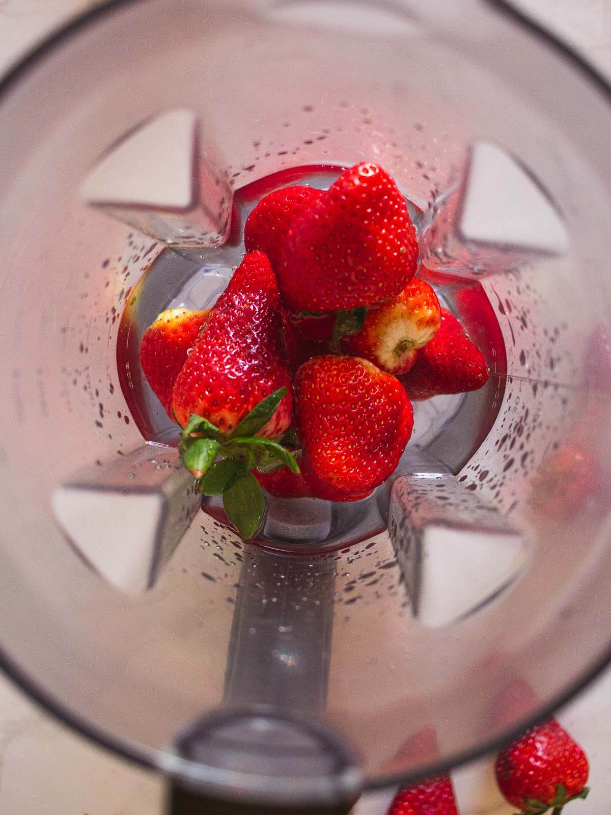fresh strawberries and water in blender jar