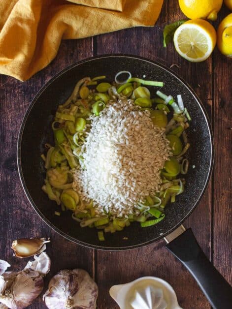 add carnarolli rice on top of the grilled sliced leeks