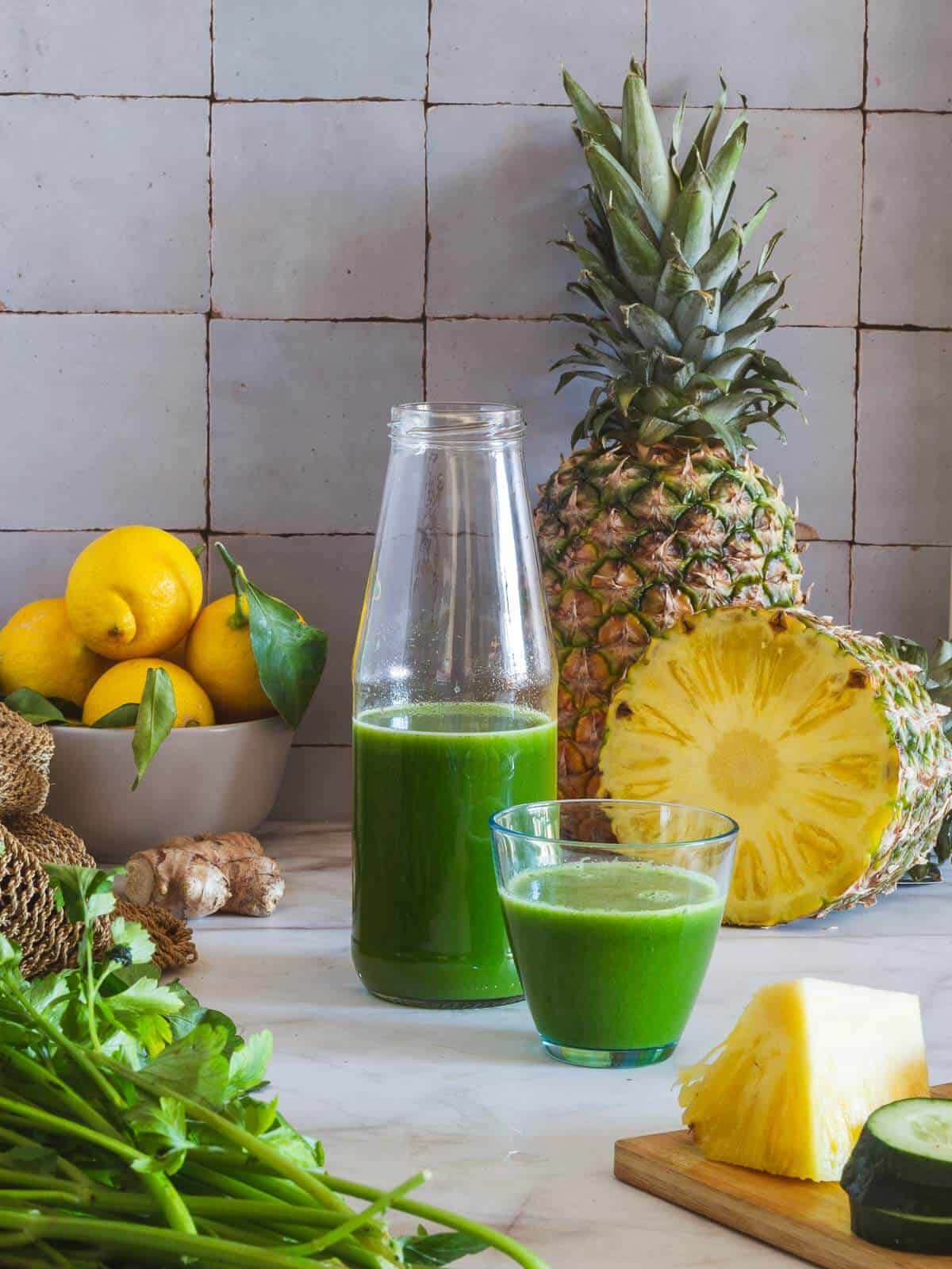 Weight Loss Juice bottle with a served glass, next to freshly chopped pineapple.