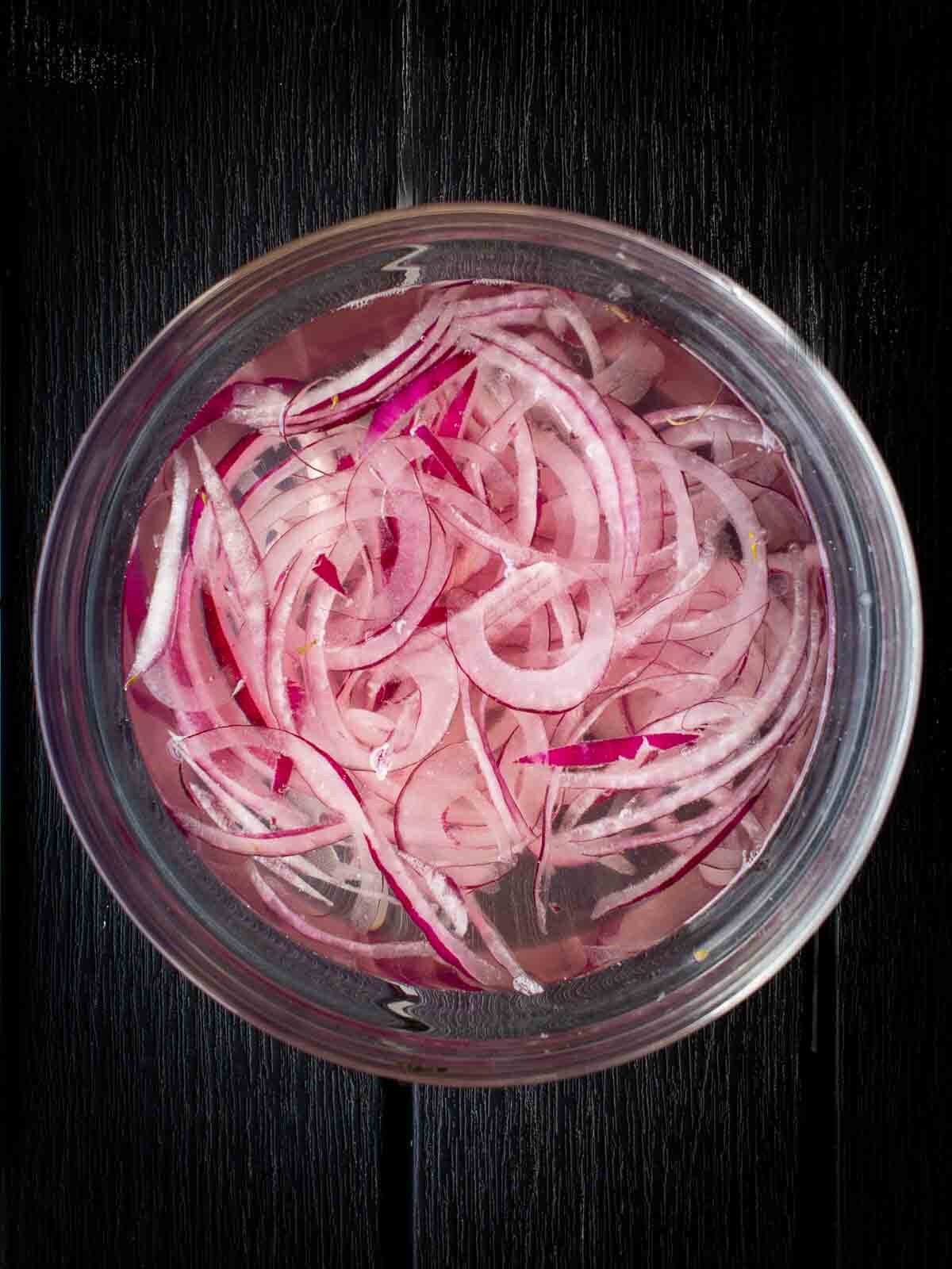 soaking sliced red onions in water and vinegar.