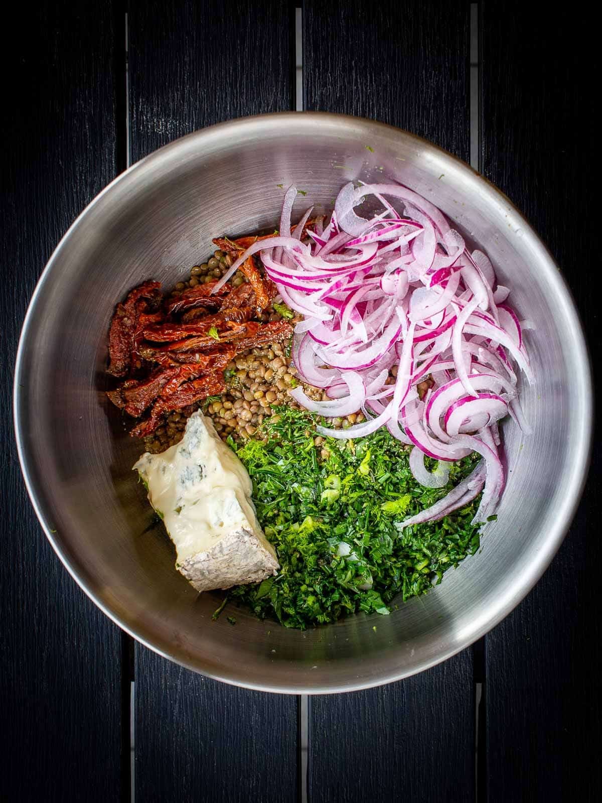 all Mediterranean lentil salad ingredients in a mixing bowl.