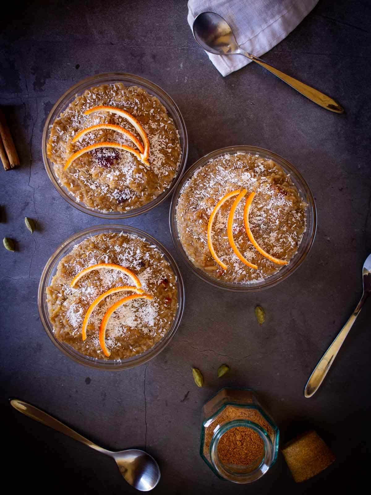 cardamom rice puddings in a table with cardamom pods.