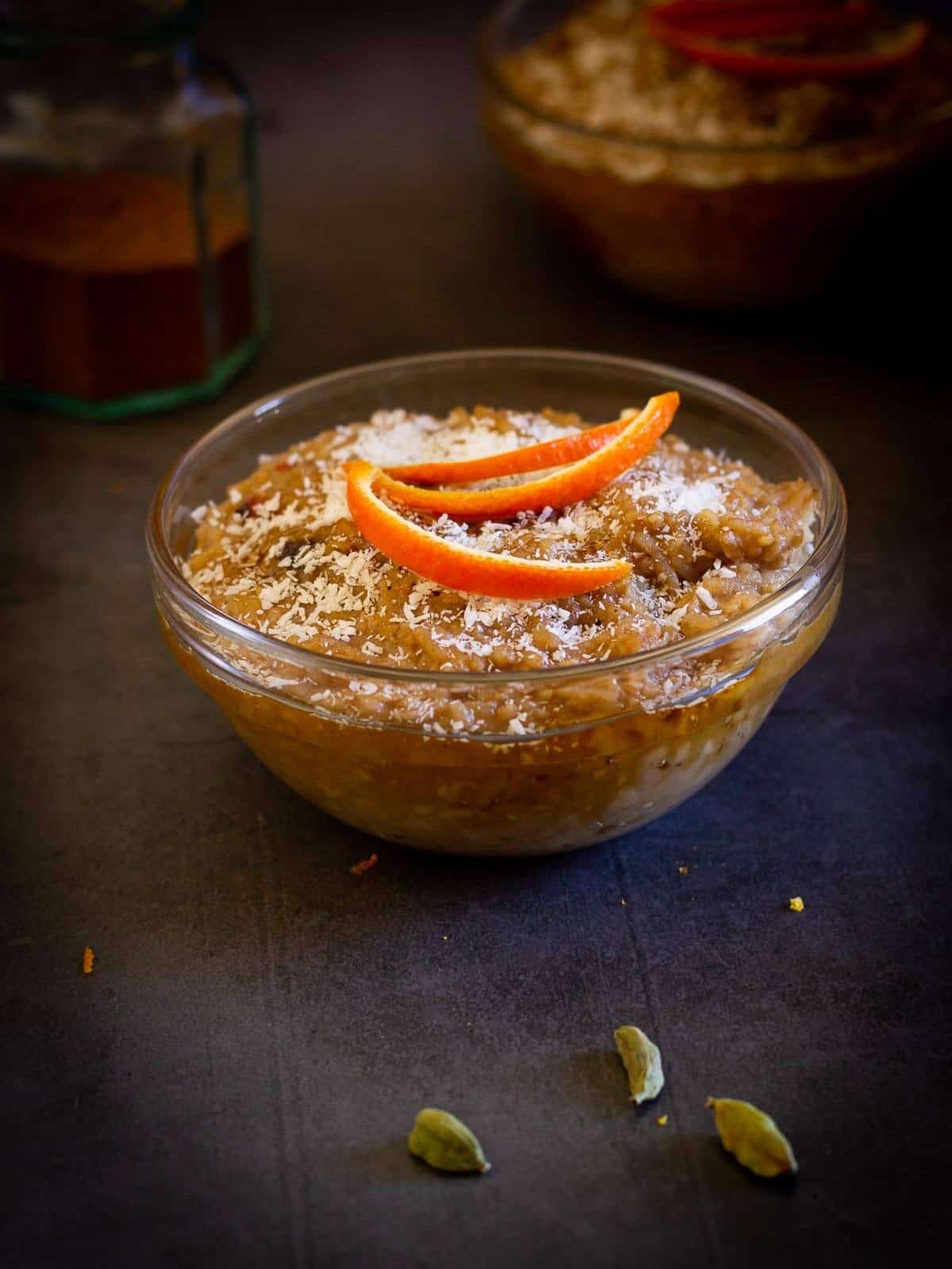 cardamom rice pudding served with cinnamon container on the back.