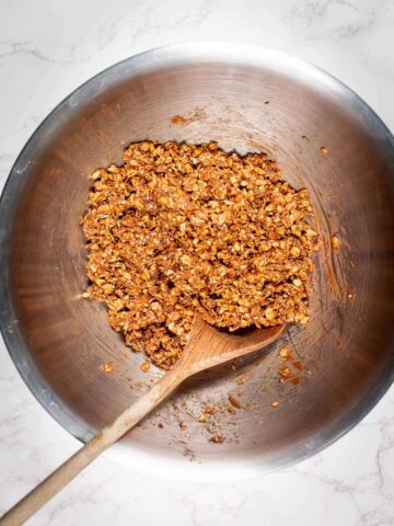 mix granola in a bowl with a wooden spoon.