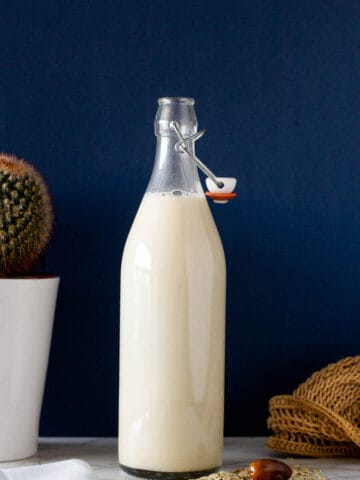 bottling fresh oat milk in a glass container.