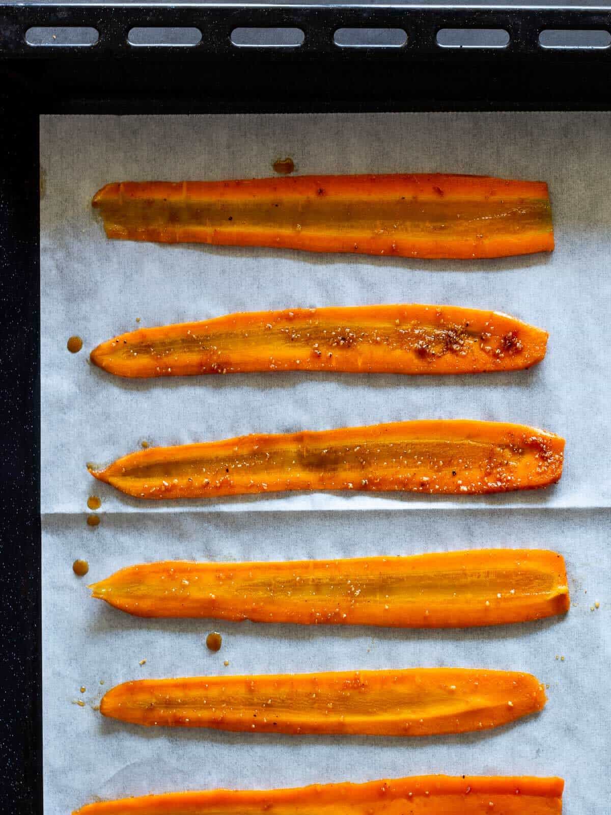 carrot strips placed on lined baking sheet with parchment paper