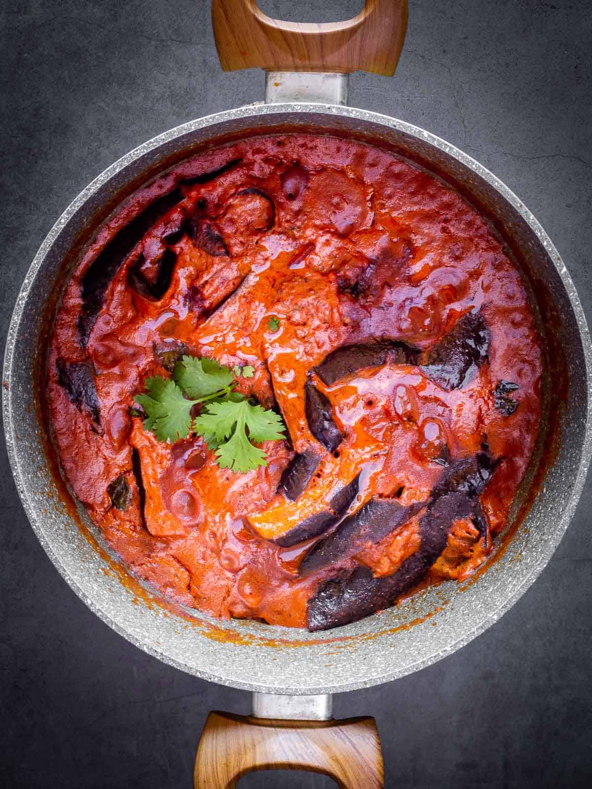 cooking Eggplant Curry with tomato sauce in a large pot.