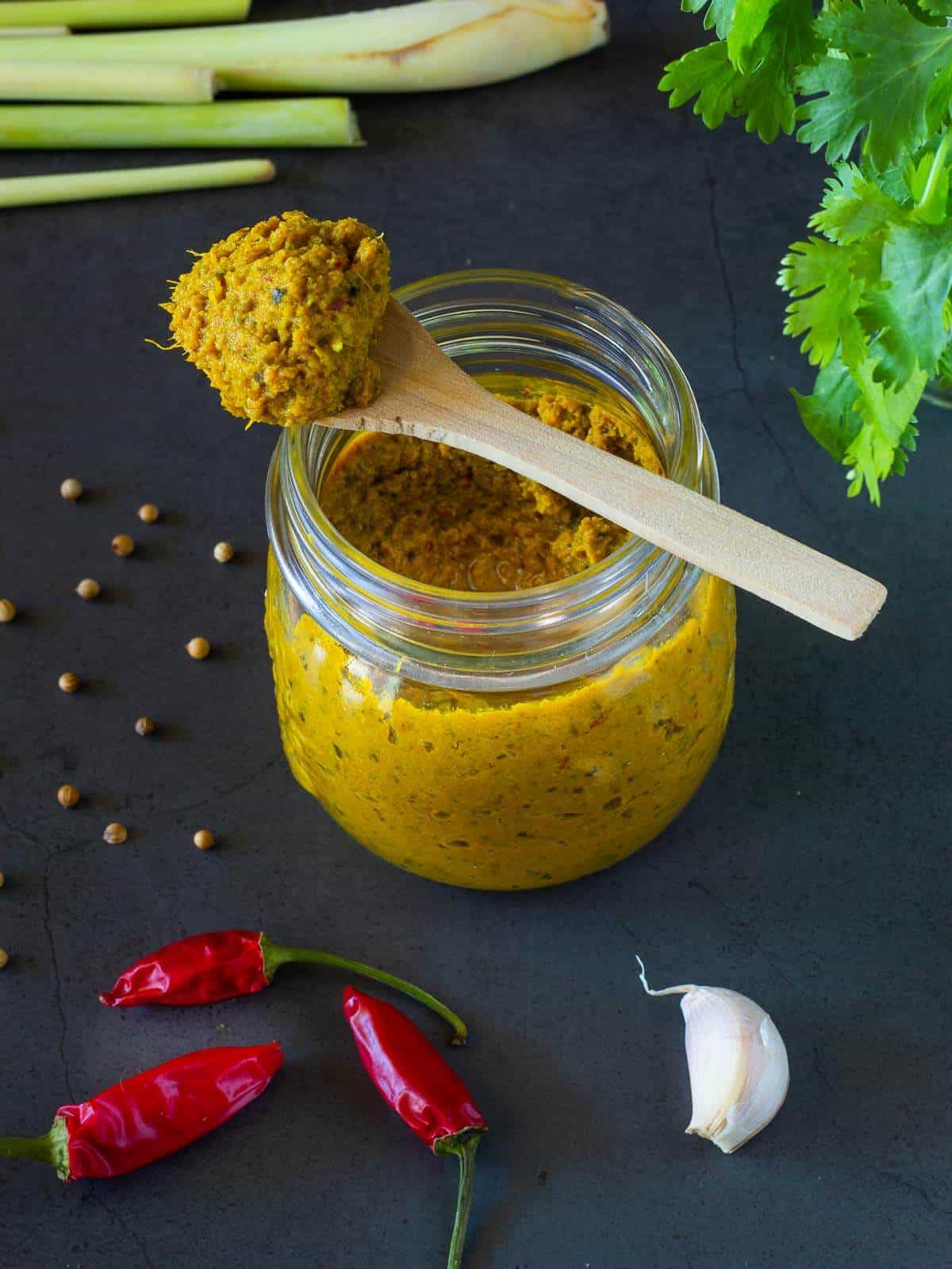 Thai Yellow Curry Paste in a jar with a spoon.