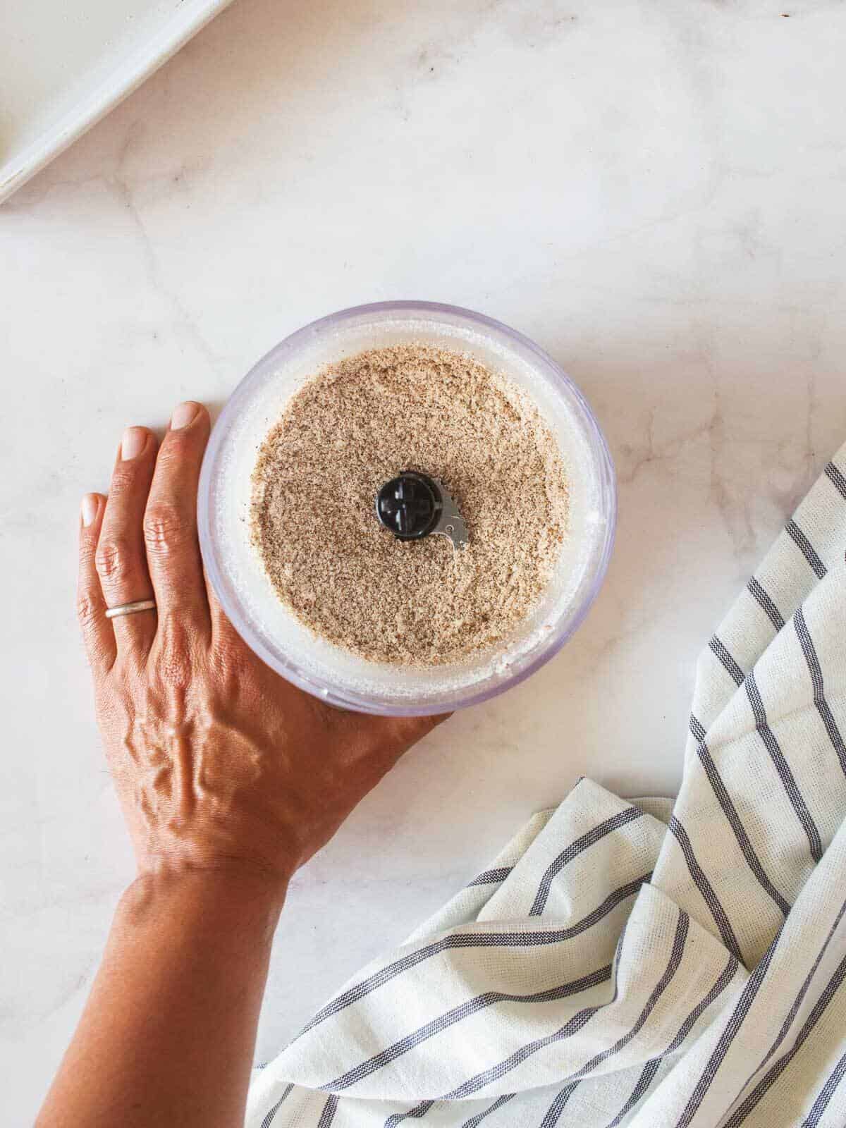 holding immersion blender with result almond meal