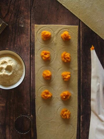 place the pasta sheet on a floured surface, mark the ravioli slightly, leaving ¼" (0.5 cm), between each one; then put filling