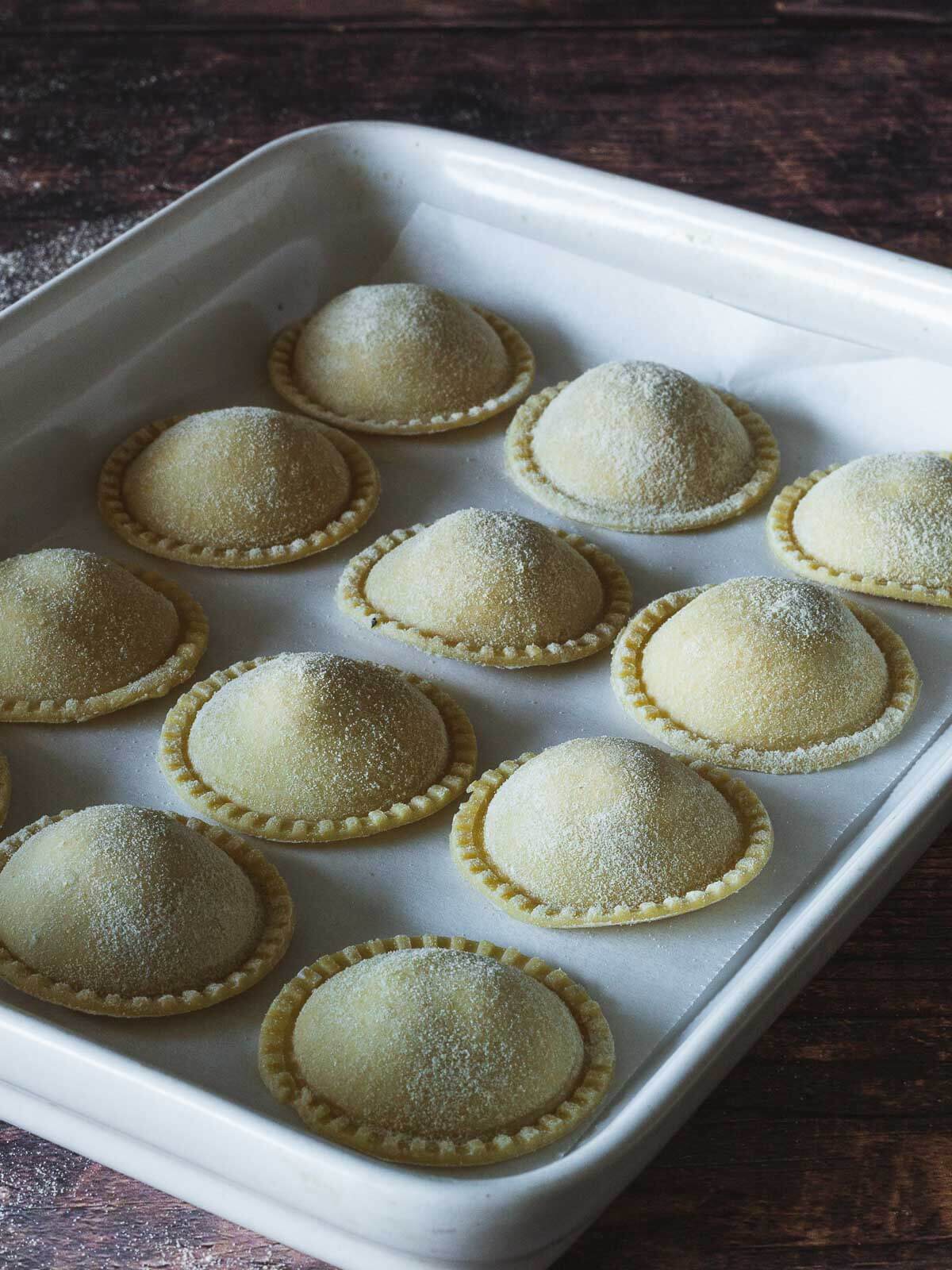 flour a baking tray and sprinkle some flour on top of the ravioli