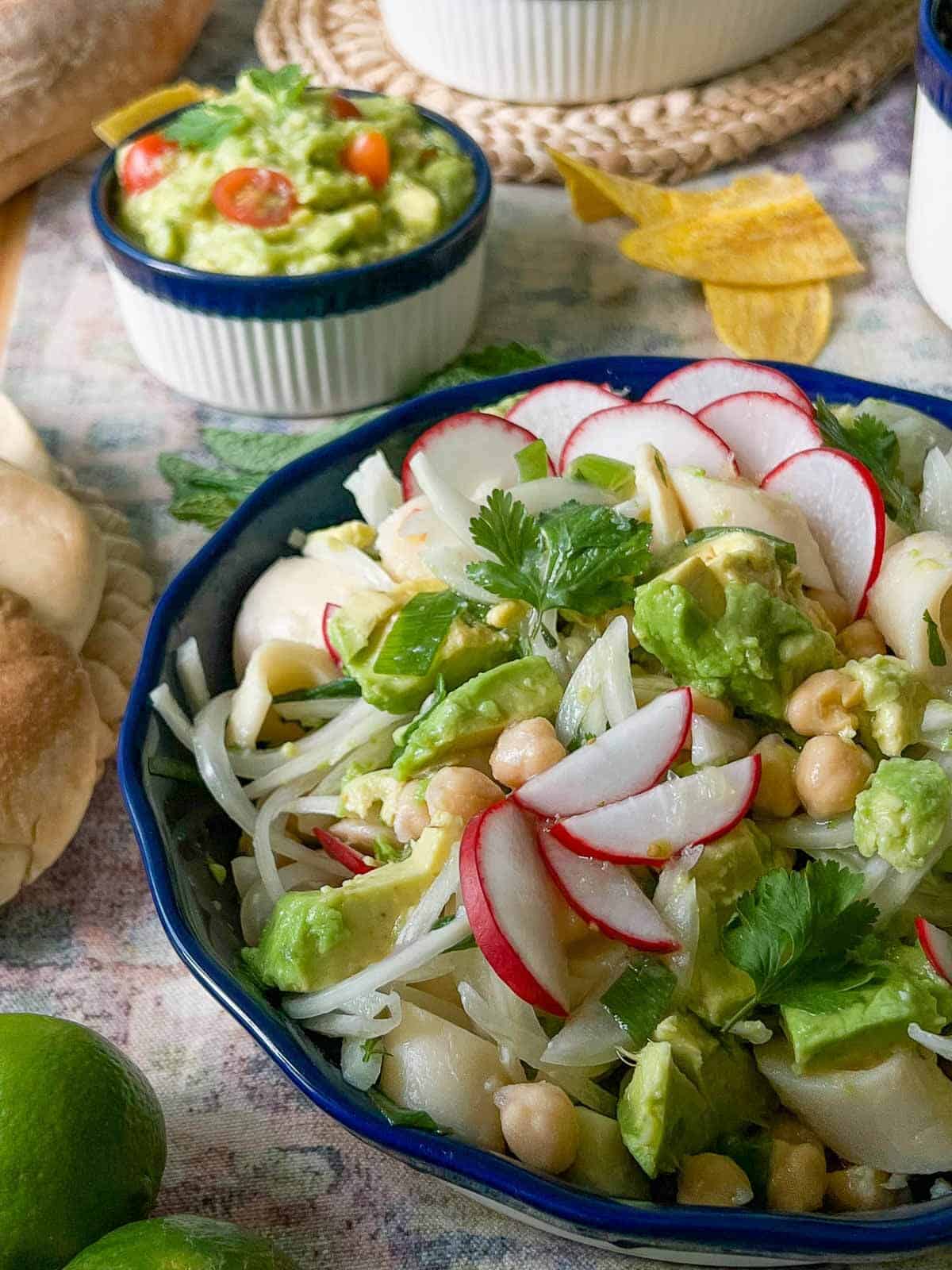 hearts of palm ceviche in a table with plantain chips and guacamole