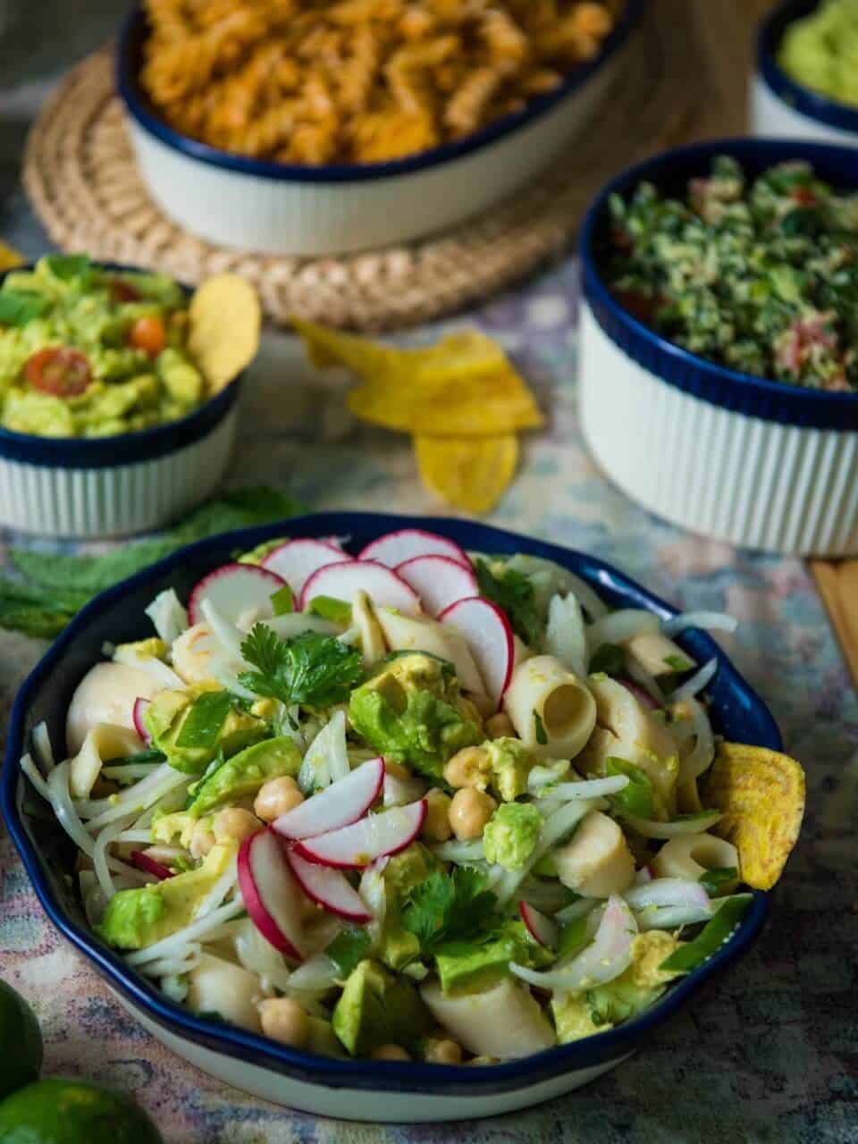 served hearts of palm ceviche in a table with tabbouleh salad and guacamole