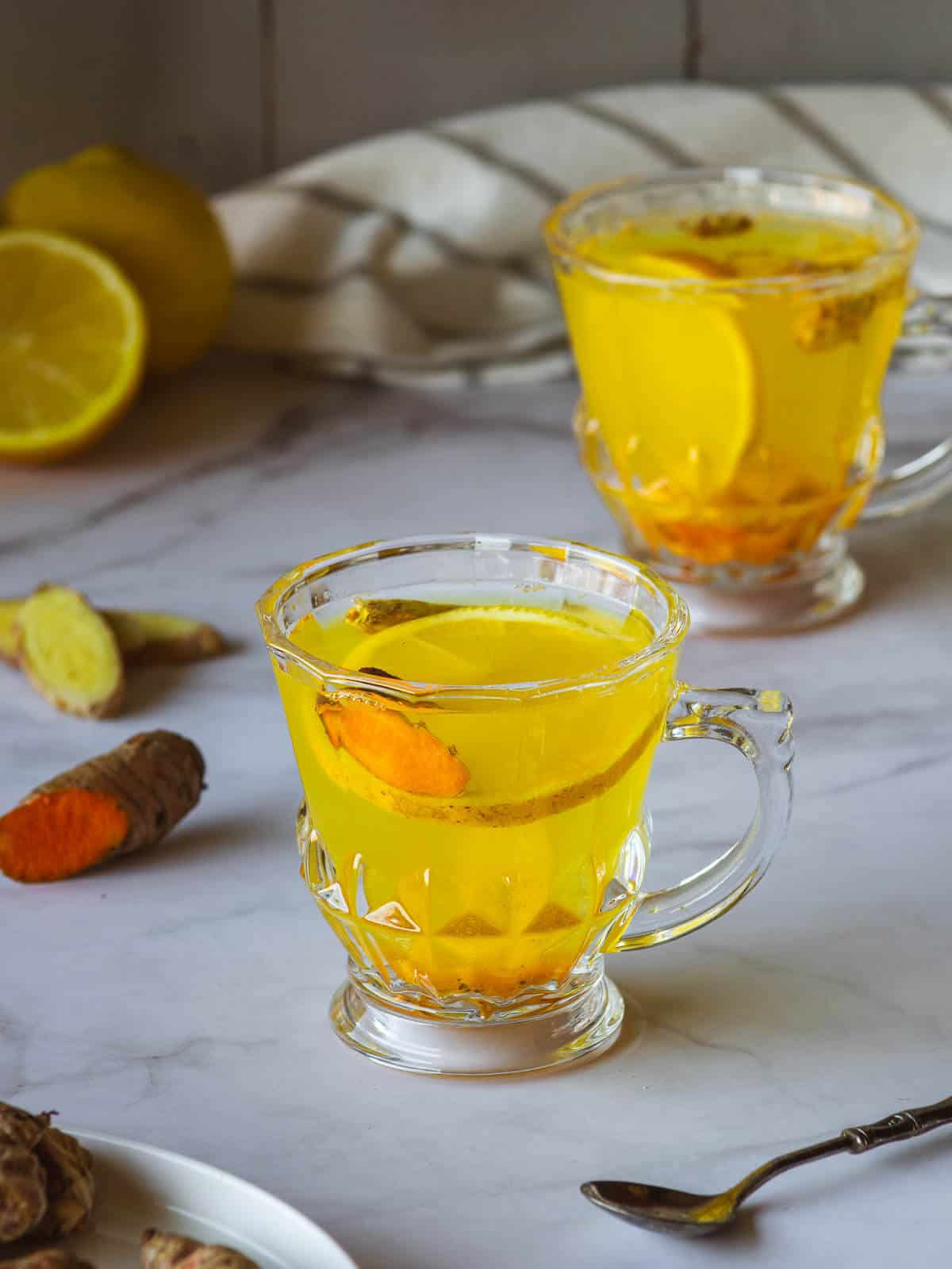 two cups with lemon ginger turmeric tea.