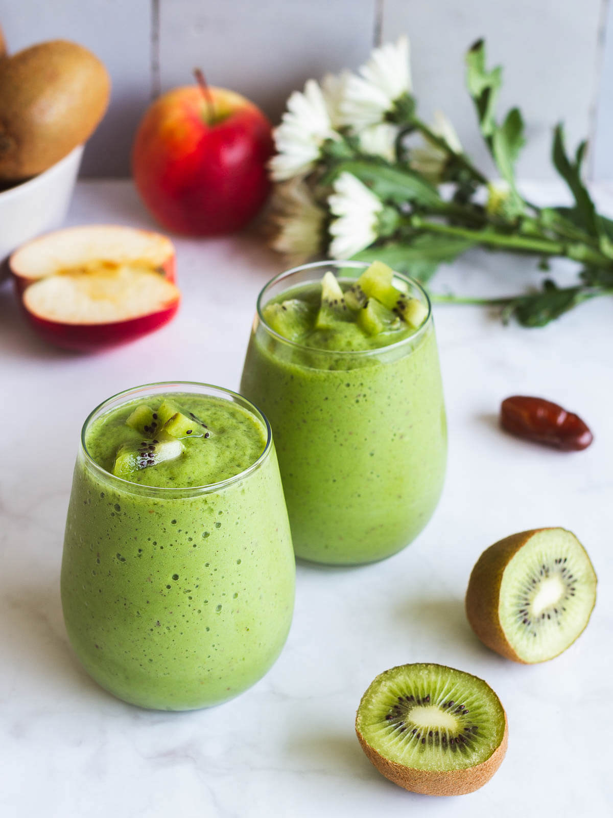 apple spinach and kiwi smoothie served in two glasses