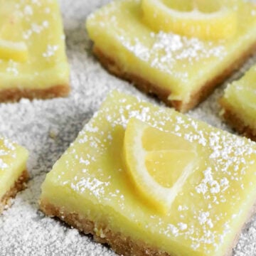 vegan lemon bars with a piece of lemon on top