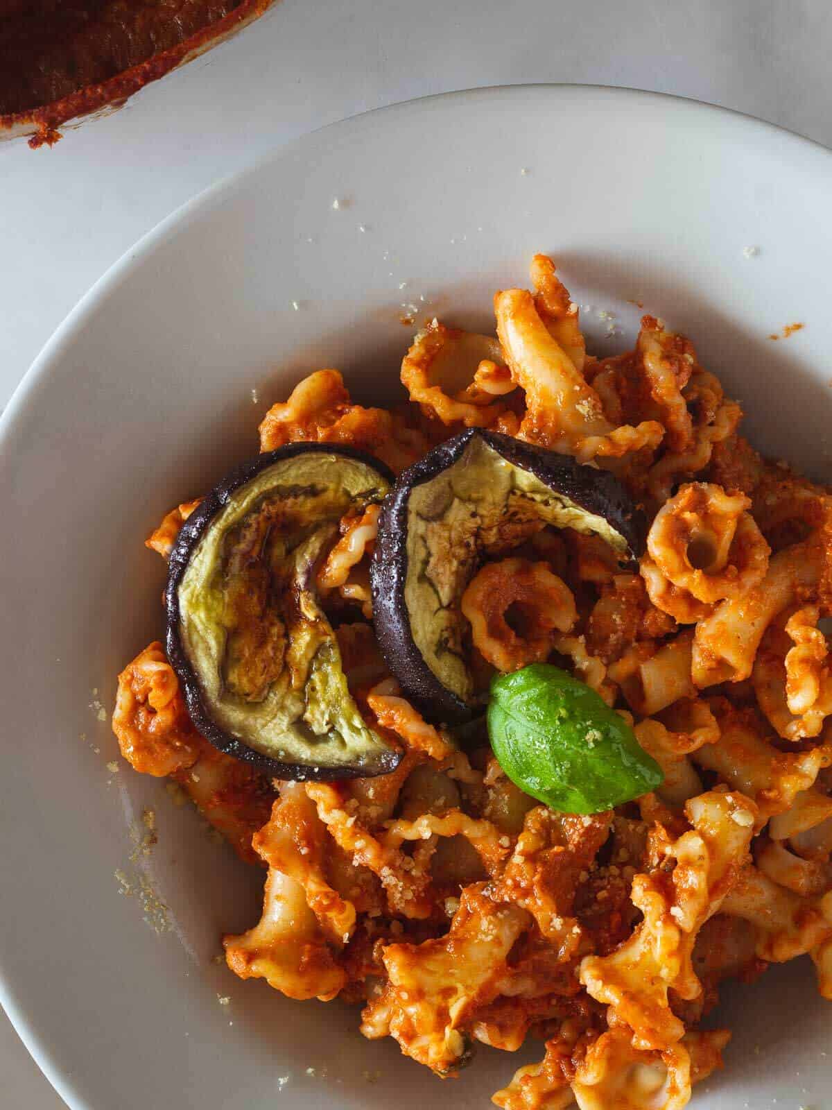 creamy eggplant pastta with tomato ricotta sauce folded into curly pasta.