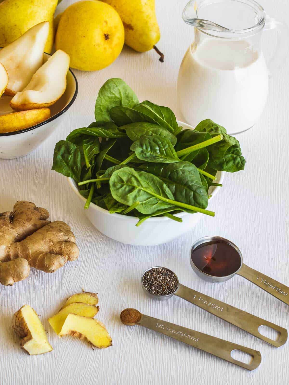 frozen spinach smoothie with ginger measured ingredients on a table.