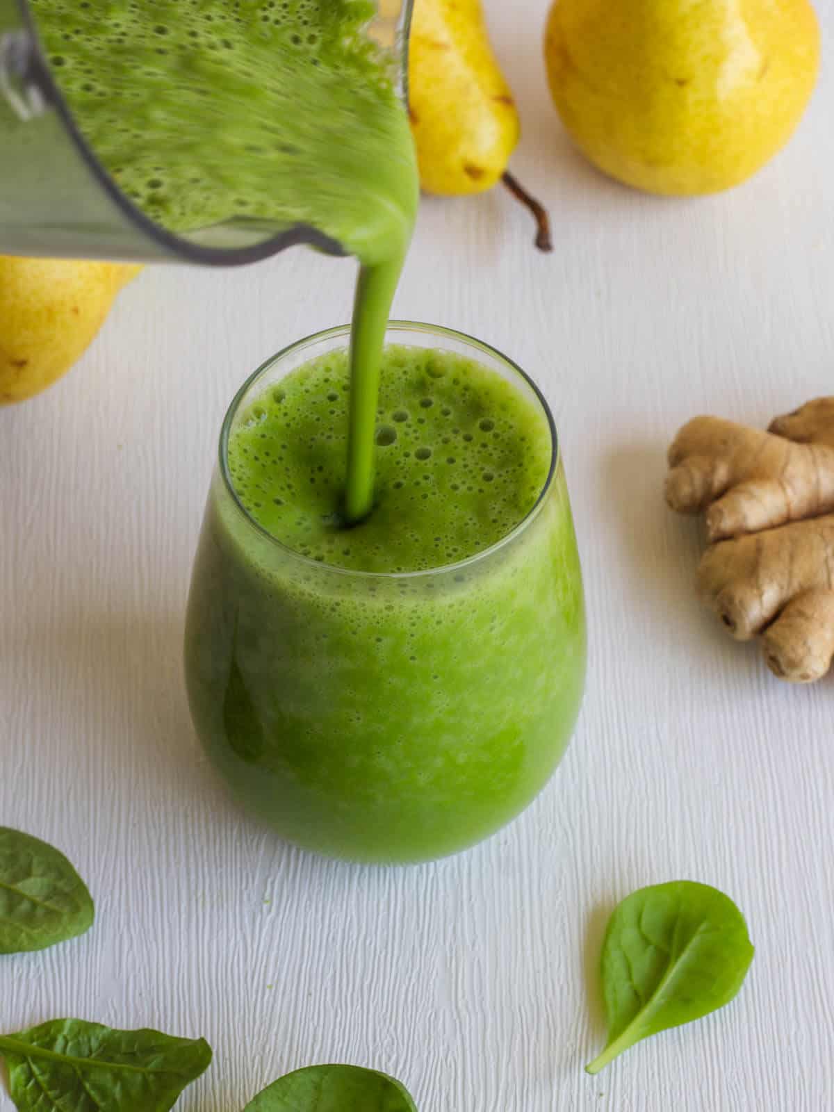 serving creamy green smoothie in a glass.