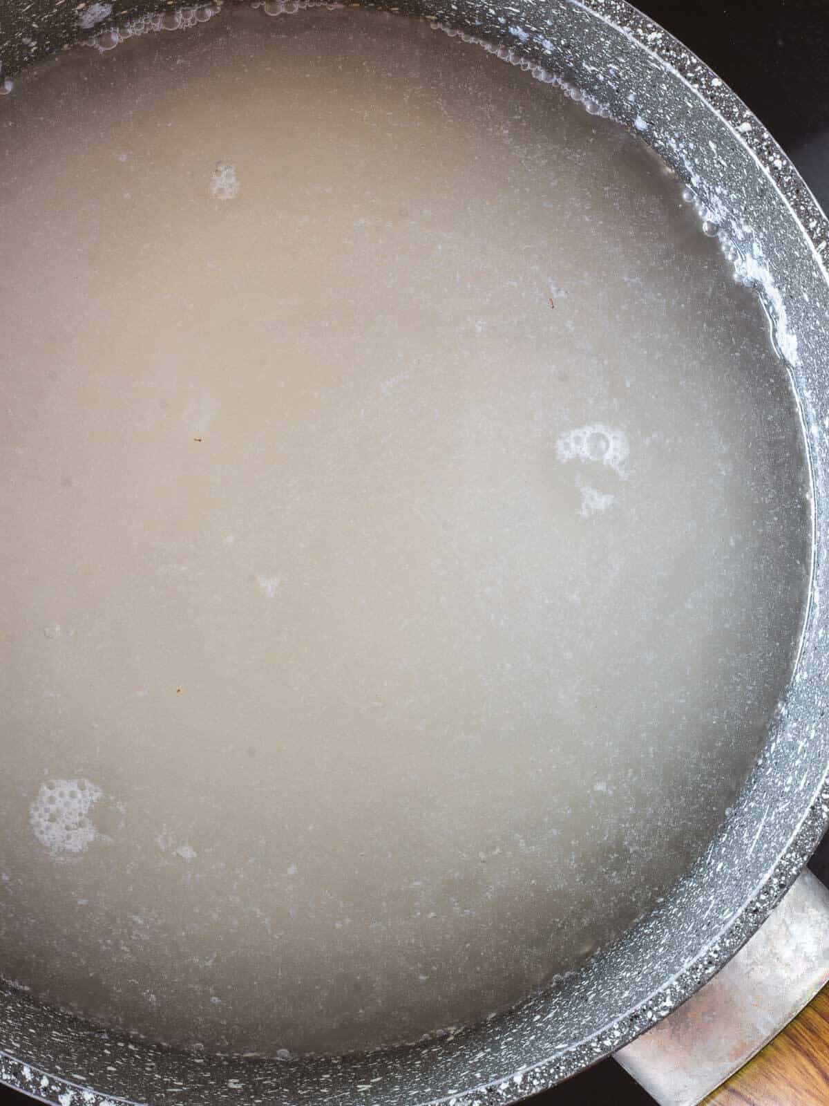 rice covered by water in saucepan
