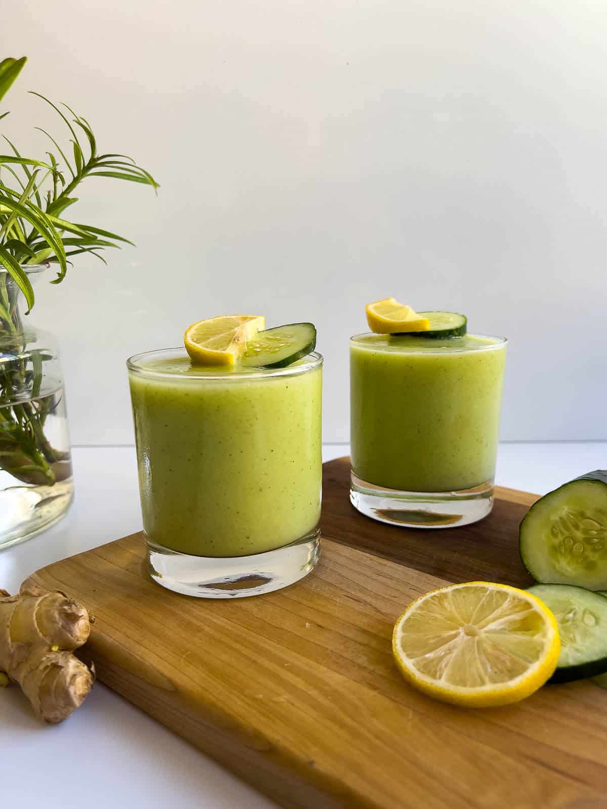 Pineapple Cucumber Smoothie served in two glasses topped with pineapple chunks and cucumber smoothie