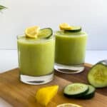 Pineapple Cucumber Smoothie served in two glasses topped with pineapple chunks and cucumber smoothie featured