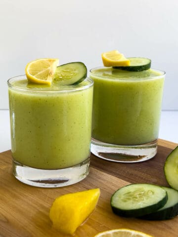 Pineapple Cucumber Smoothie served in two glasses topped with pineapple chunks and cucumber smoothie featured