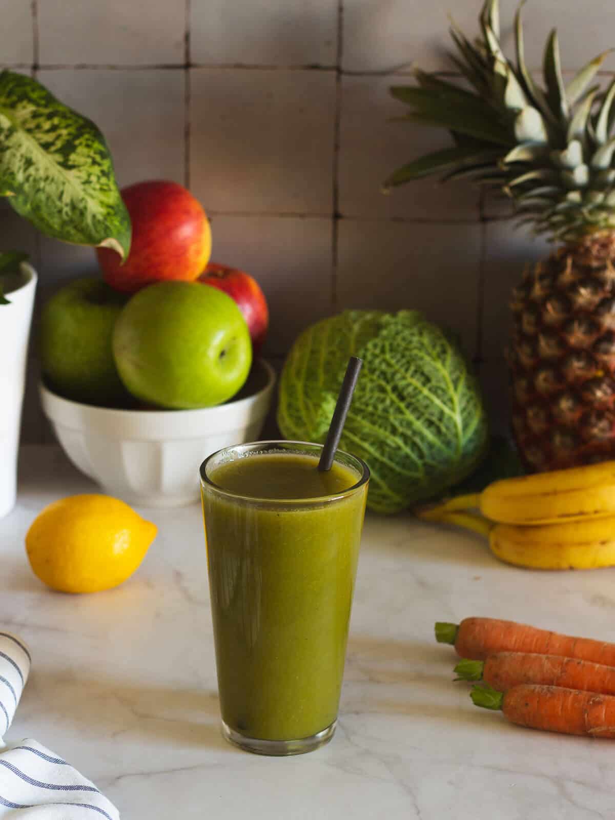 smoothie with a straw a fruits on the background.