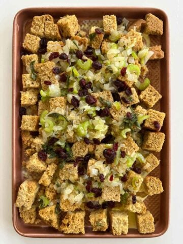 cranberries, egg replacement, vegetable broth, and remaining melted butter, non-dairy milk, and salt on a baking sheet before baking.