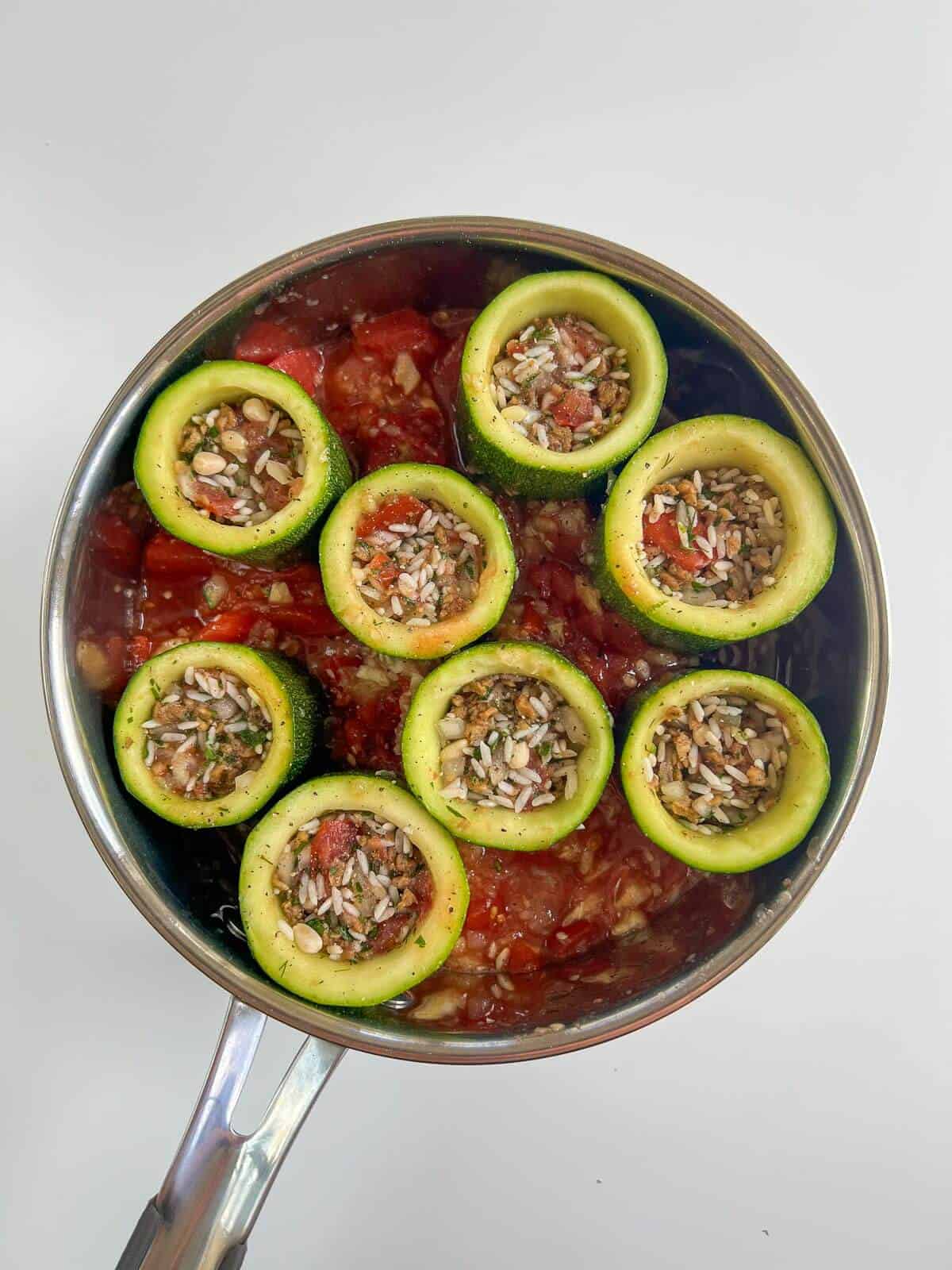 uncooked stuffed zucchini in saucepan.