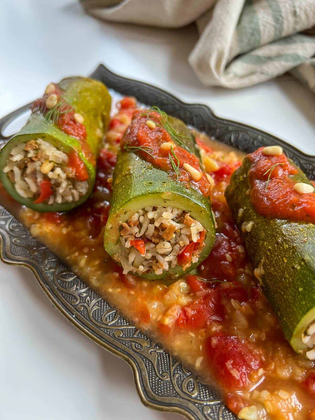 lebanese stuffed zucchini with tomato sauce on top.