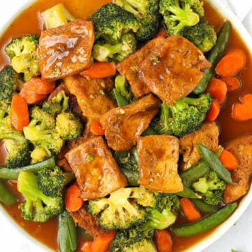 braised tofu with broccoli and carrots in white bowl.