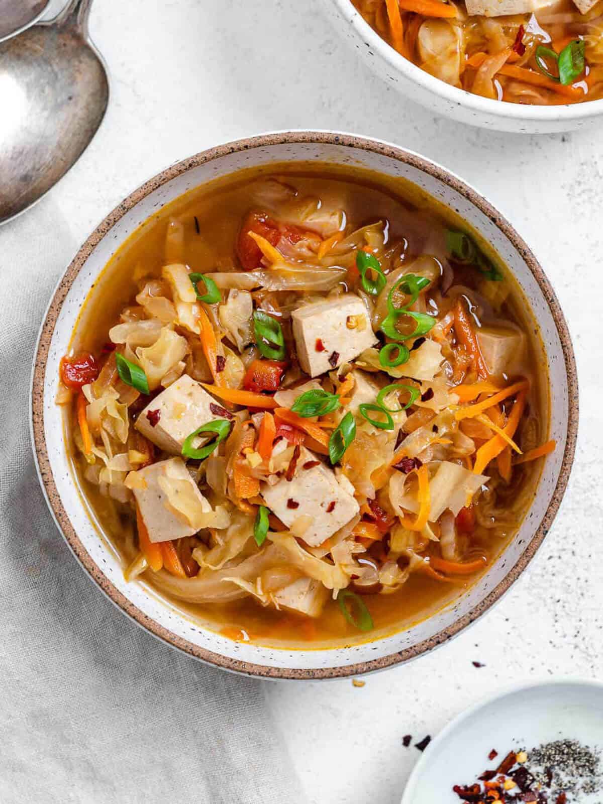 tofu chinese soup topped with green onions.