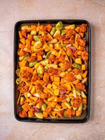 baking sheet with all the vegetables spread over and crumbled chorizo and garlic on top.