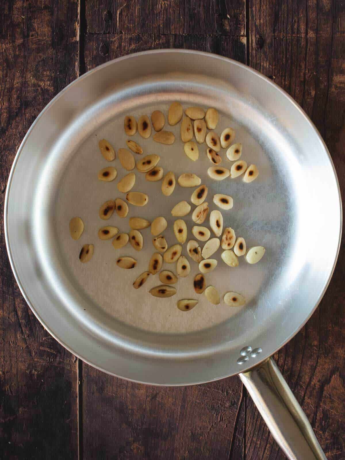 toasted blanched almonds on a skillet.