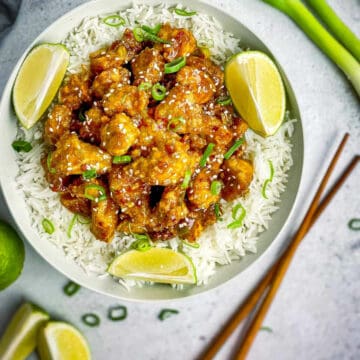 general tso tofu recipe served in flat white plate with lemon wedges.