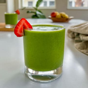strawberry spinach banana smoothie on a table featured image.