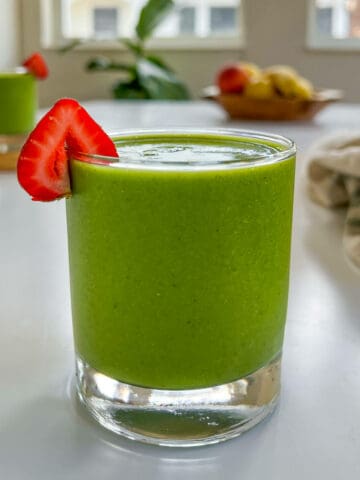 strawberry spinach banana smoothie on a table featured image.