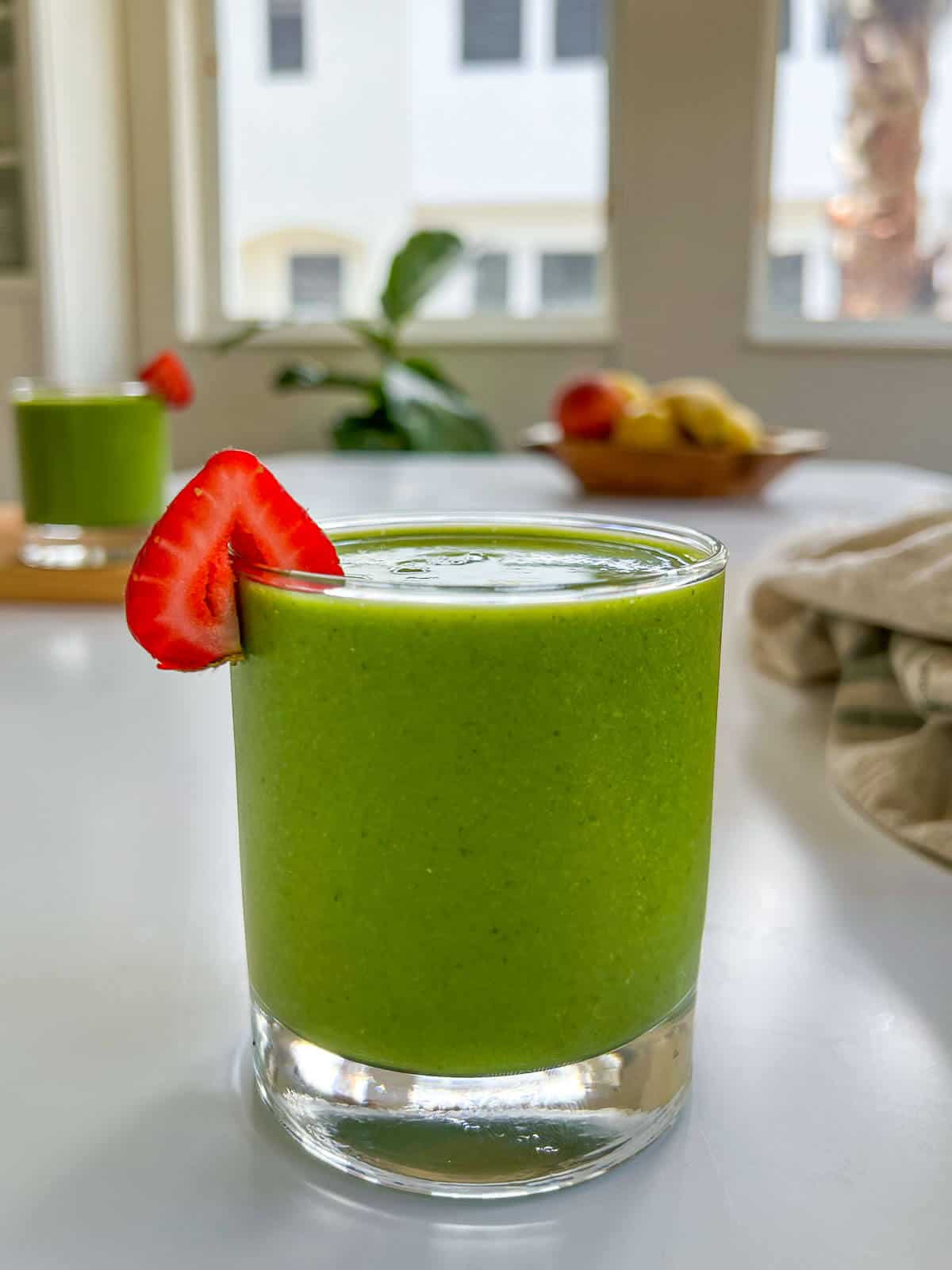 strawberry spinach banana smoothie on a table.