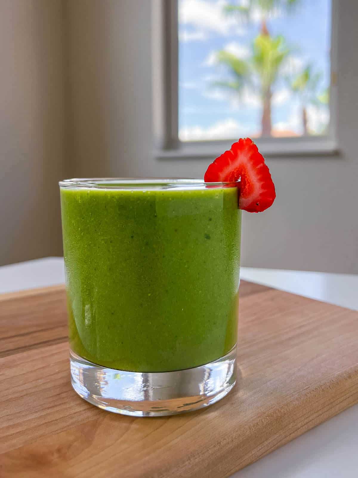 strawberry spinach banana smoothie on a table.