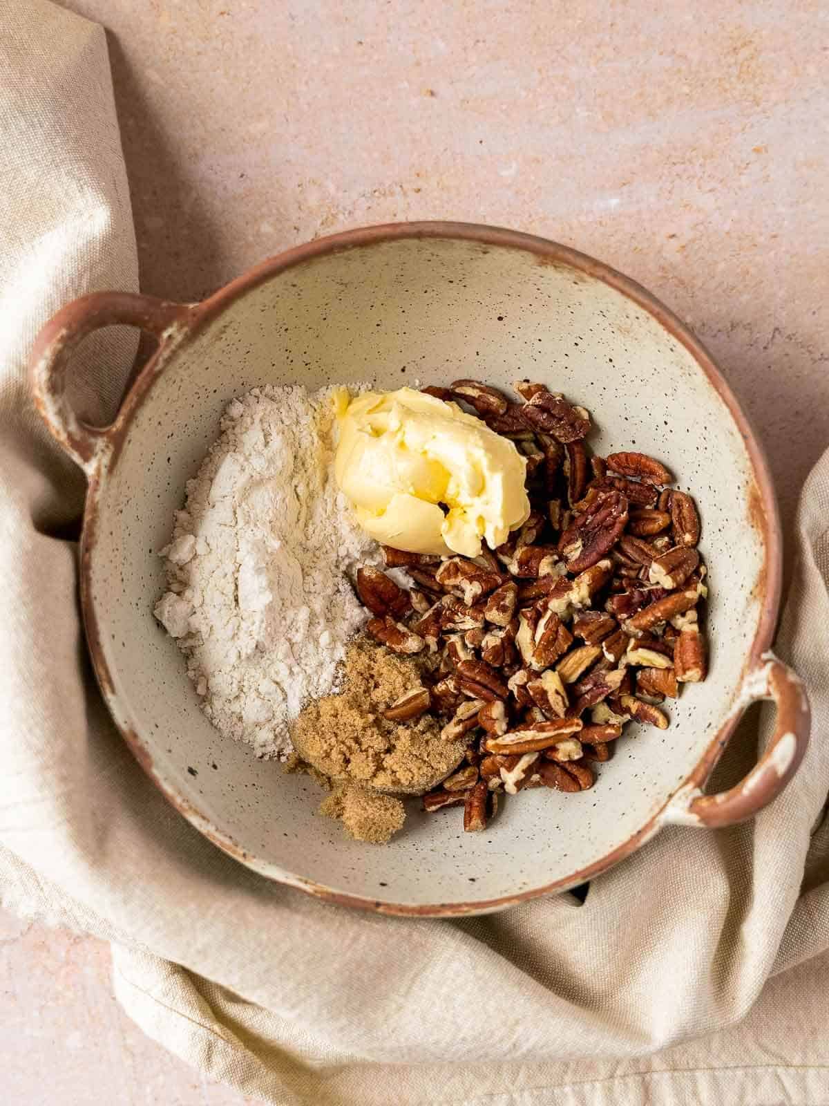 bowl with gluten-free flour, butter, pecans, and brown sugar.