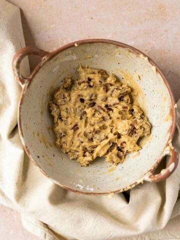 bowl with pecan nuts mixed with melted vegan butter and brown sugar