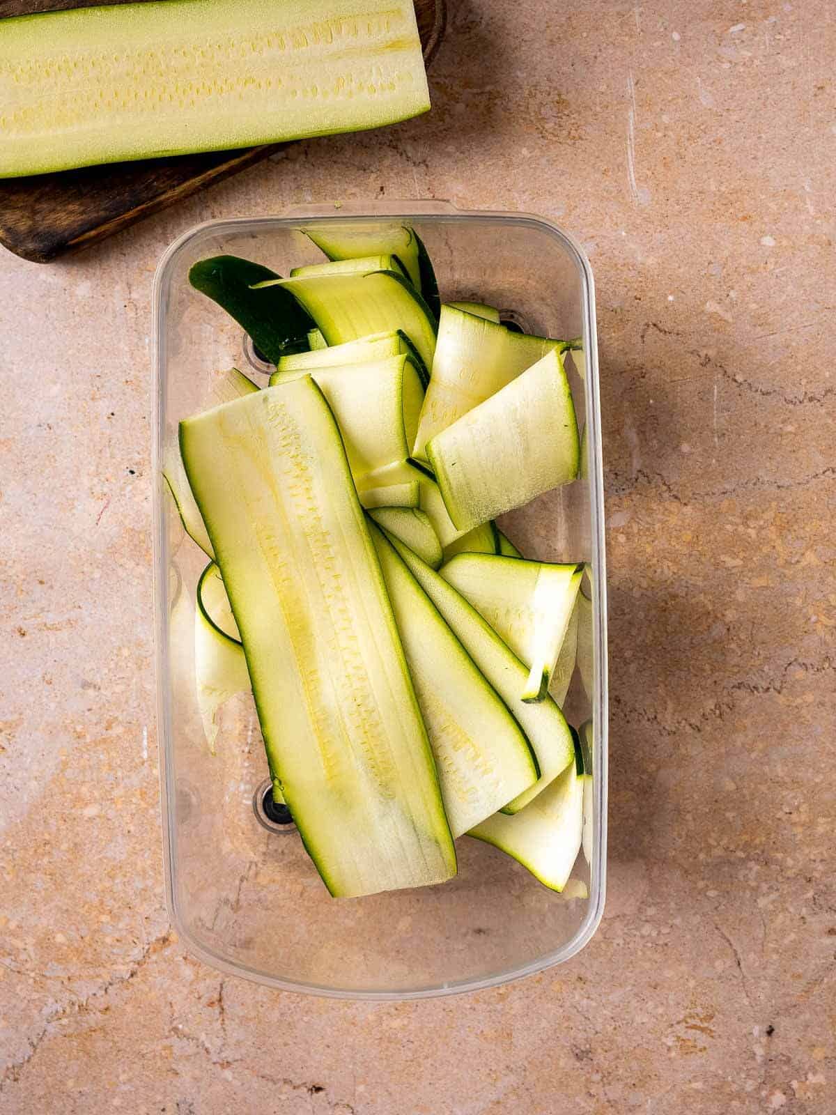 bucket with freshly sliced zucchini noodles, made with a mandoline.