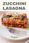 vegan gluten-free lasagna slice with sprinkled vegan parmesan cheese in a white plate pin.