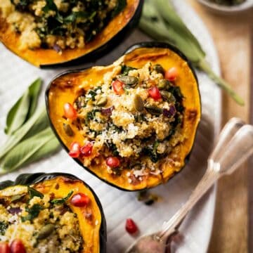 close up of stuffed acorn squash with pomegranate seeds featured