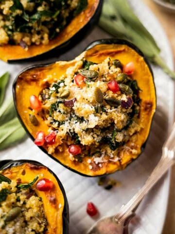 close up of stuffed acorn squash with pomegranate seeds featured