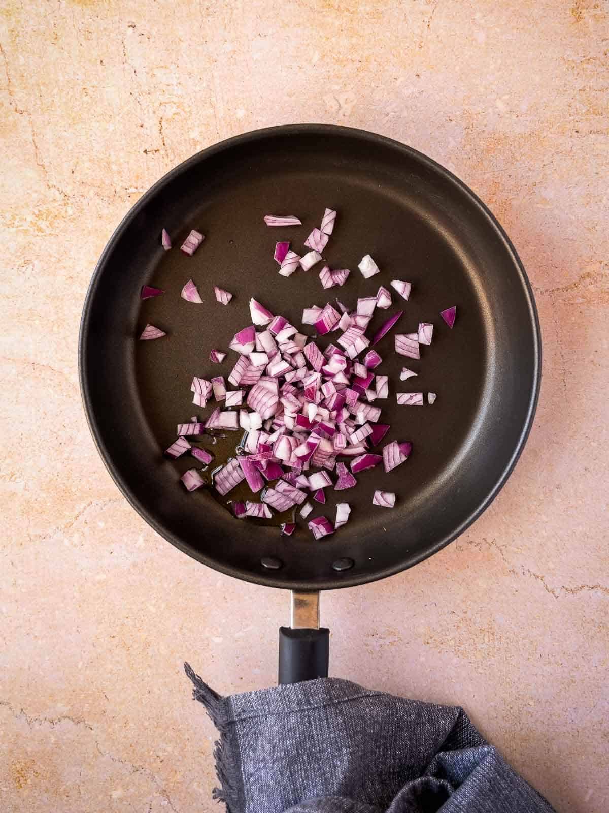 stir fry chopped red onions in a skillet.
