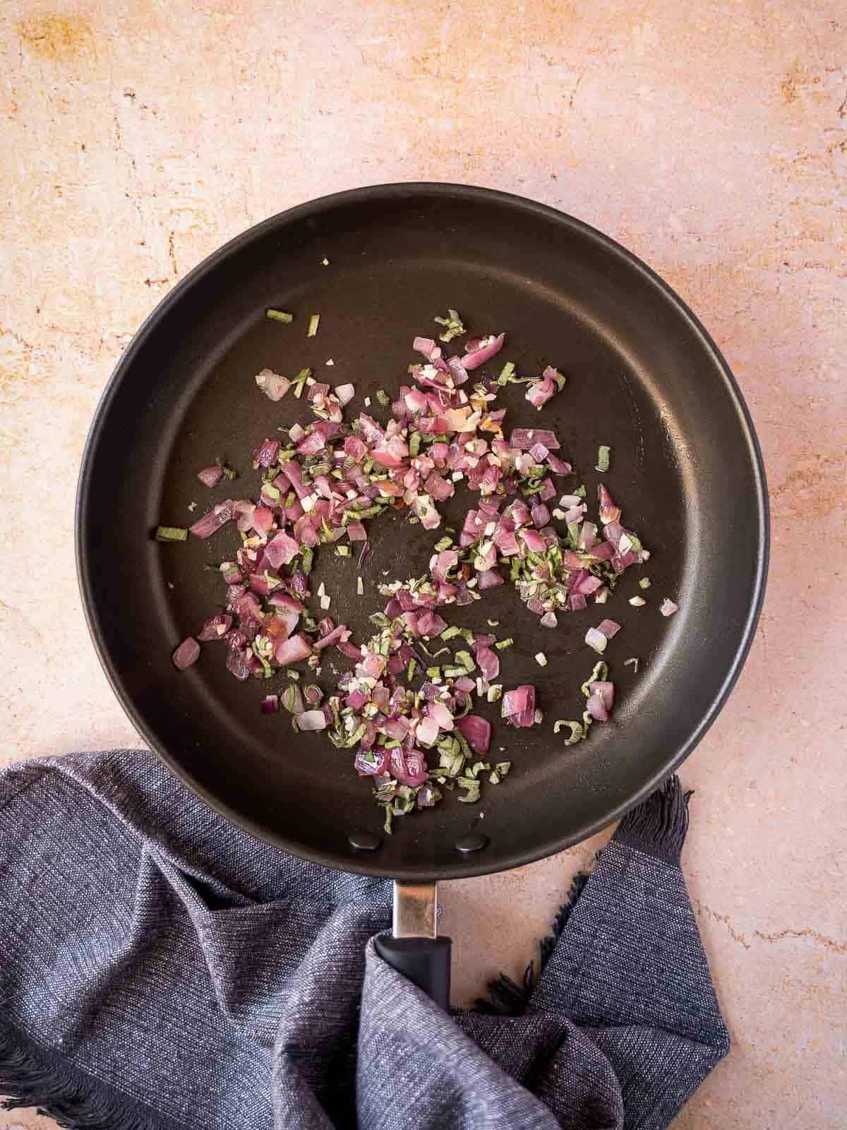 stir frying the chopped red onions with herbs.